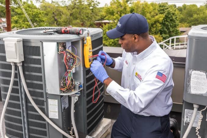 Technician inspecting a rooftop air conditioning unit