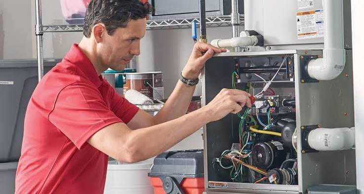 Technician inspecting a residential furnace control panel
