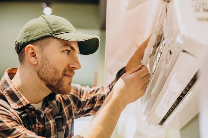 Technician servicing an indoor wall-mounted air conditioner