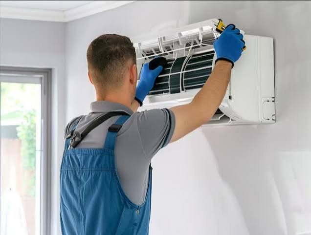 Technician cleaning an indoor air conditioning cassette unit